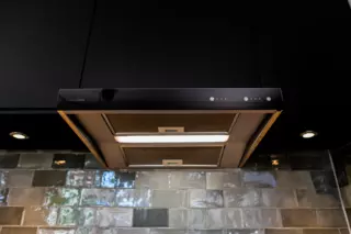 CASA R2 ventilation unit and Jazz cooker hood installed in black kitchen. Kitchen cabin door as front panel.